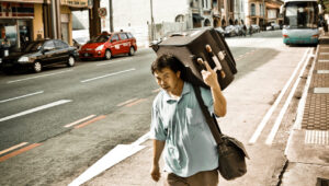 A foreign worker carries his luggage on the street