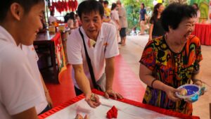 ‘Man playing five stones at a carnival’ by Kelman Chiang, from SRN’s SG Photobank