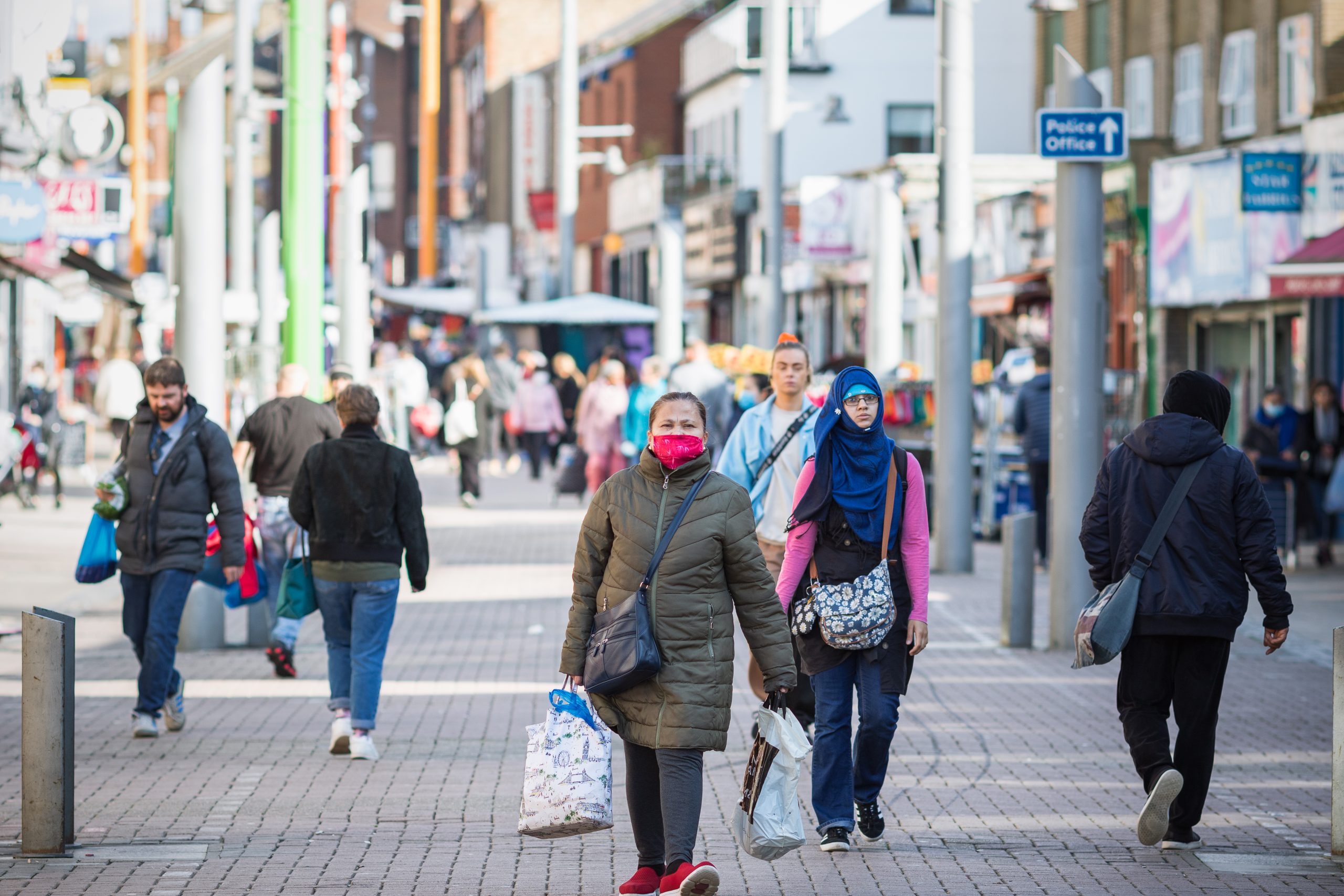 London, UK - 3 November, 2020 - An asian woman wearing a face mask while shopping at Walthamstow market