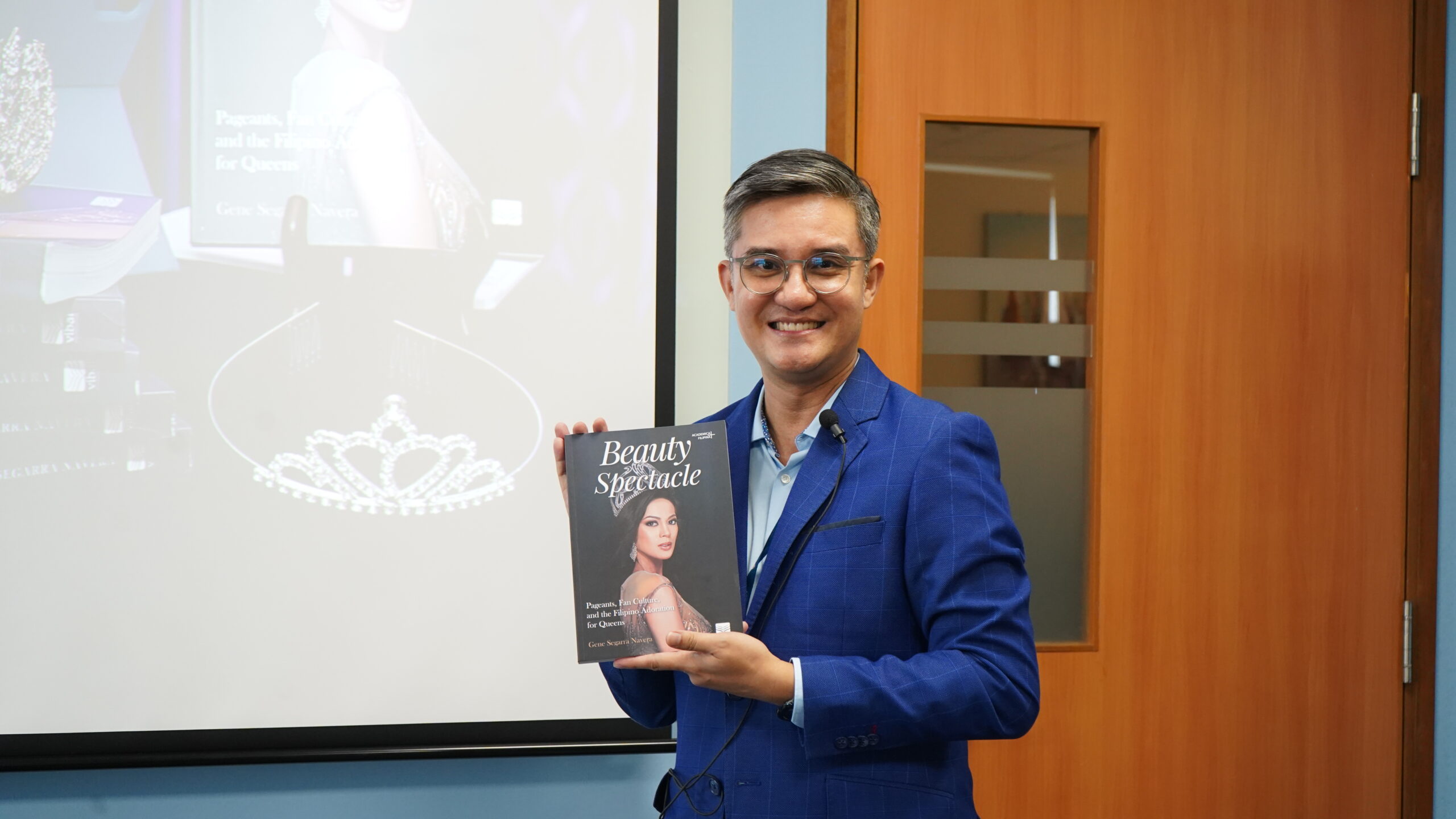 Dr. Gene S. Navera posing with a copy of his book